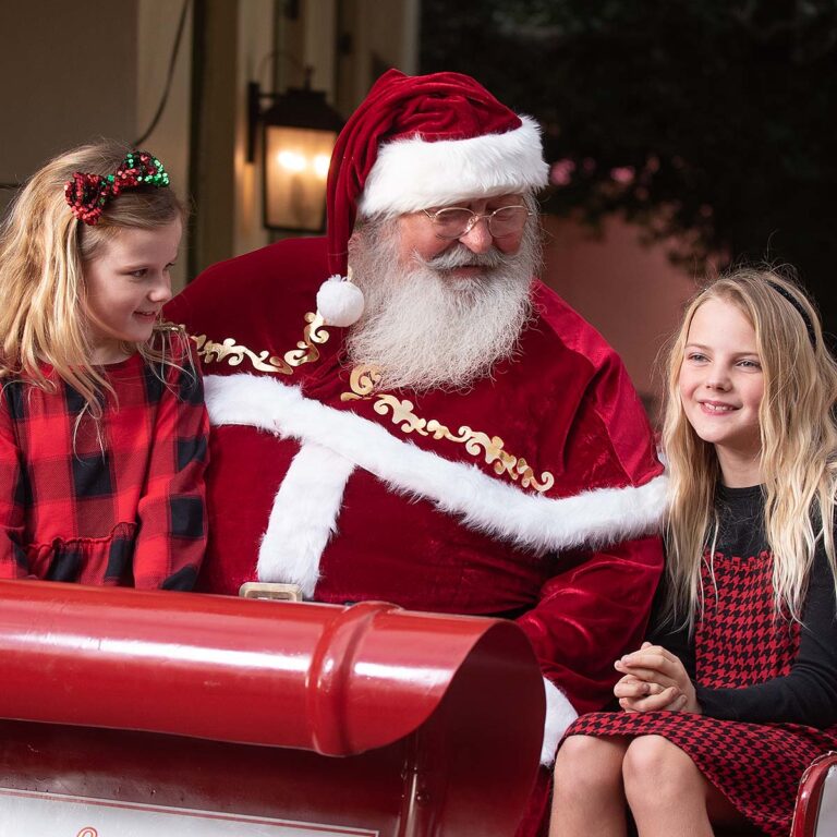 Two young guests and Santa on Santa's sleigh